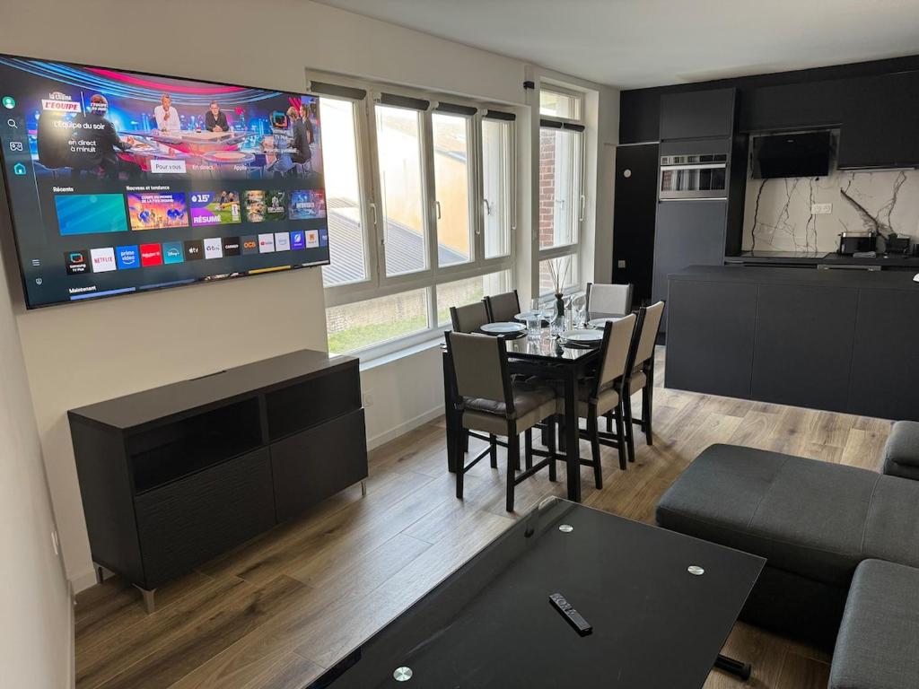 a living room with a dining table and a television at ღ L'Urban Gare - T3 Cosy Parking & Wifi in Douai