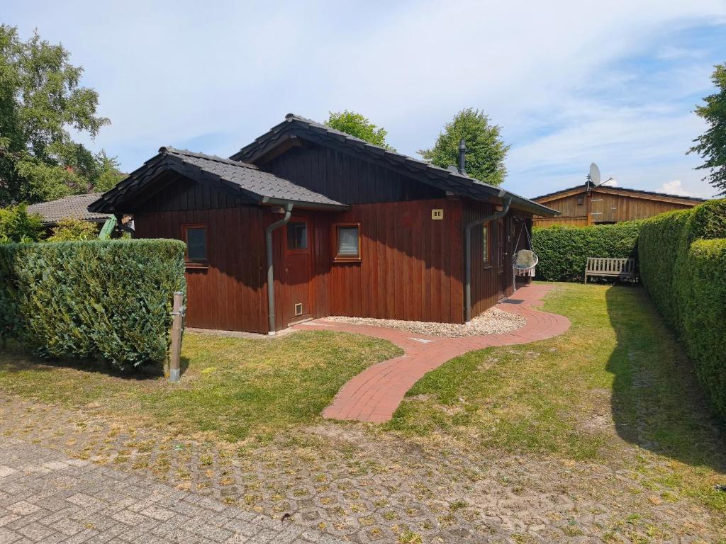 a red building with a brick walkway in front of it at Linnis Strandhaus in Garrel