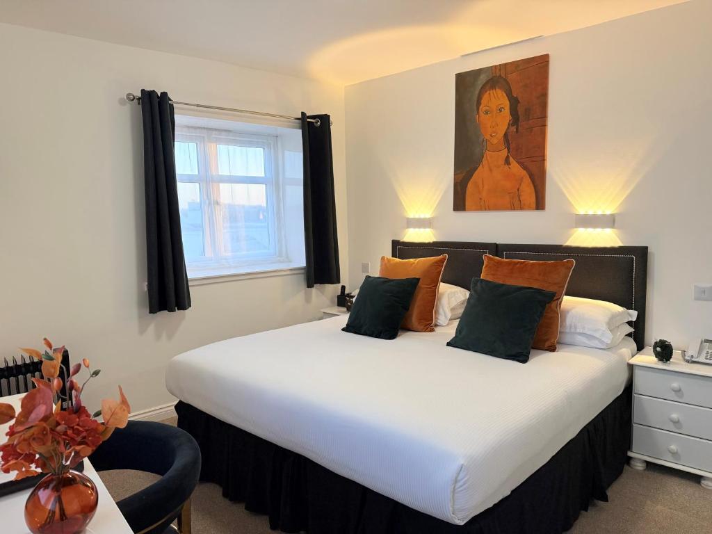 ein Schlafzimmer mit einem großen weißen Bett und einem Fenster in der Unterkunft Sarum Apart-Hotel in Saint Helier Jersey