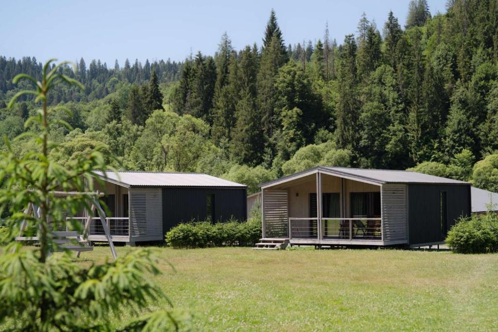 two modular homes in a field with trees at River Cottage Complex in Richka