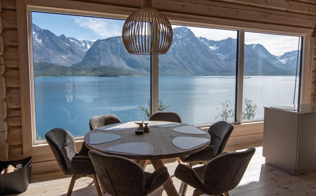 a dining room with a table and chairs and a large window at Sommarbukt Nordlys - Private Arctic Retreat near Tromsø in Tromsø