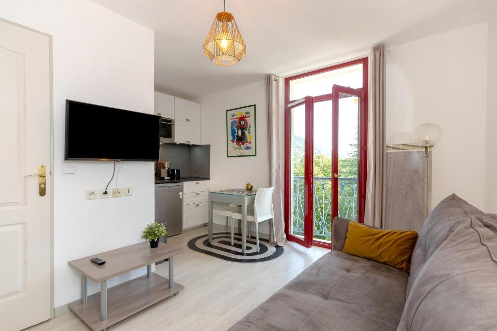 a living room with a couch and a table at Studio Le Splendid 3 Hôtel étoiles in Allevard