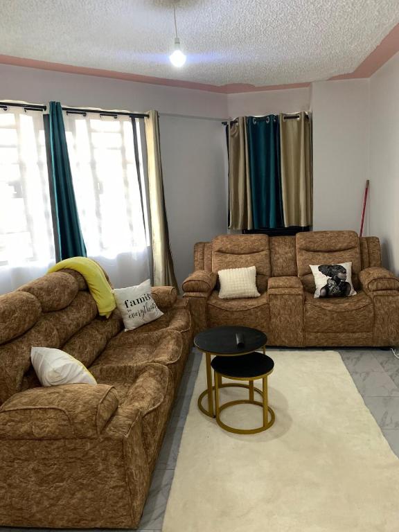 a living room with two couches and a table at Nanyuki Gratia Pad in Nanyuki