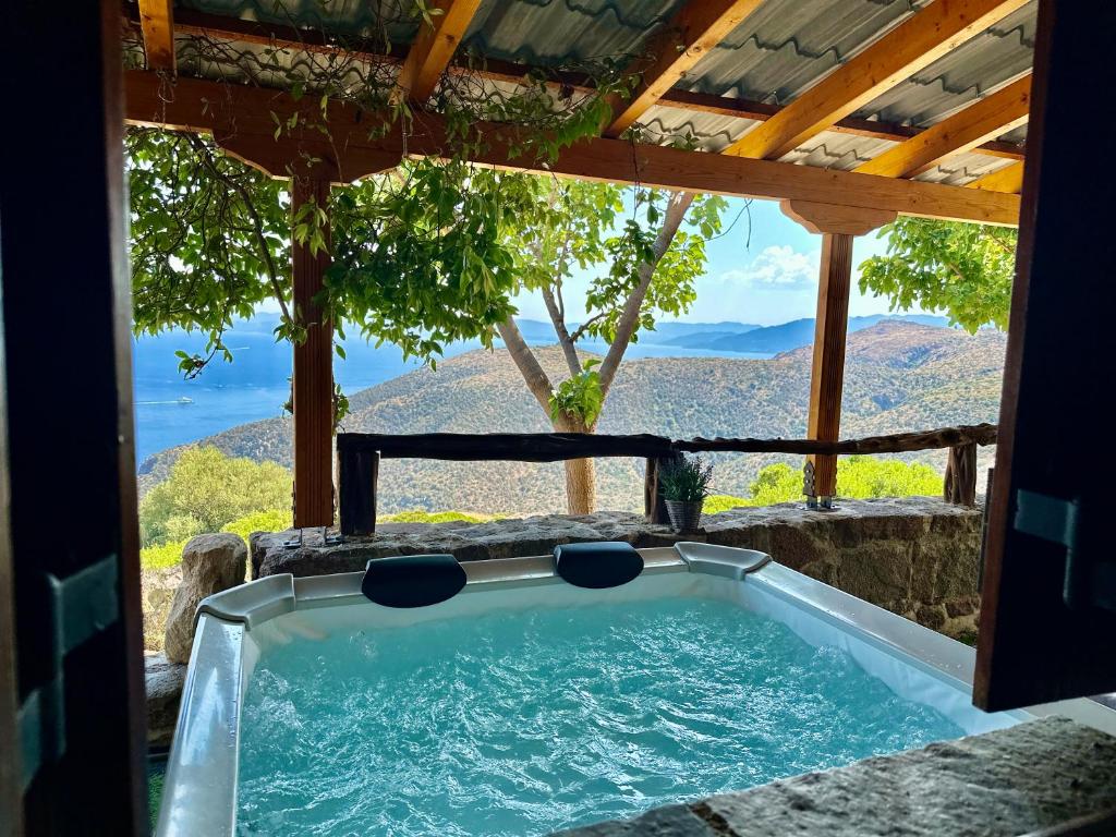 a jacuzzi tub with a view of the mountains at peaceful place in Anítsaion