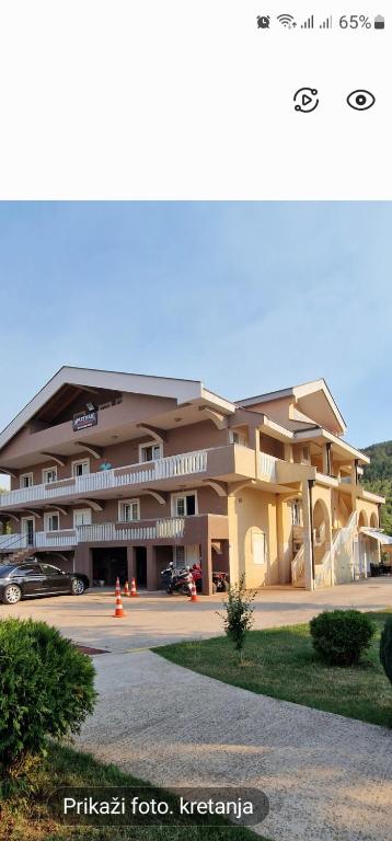 a large building with cars parked in front of it at Apartments & Camp Stanišić in Nikšić