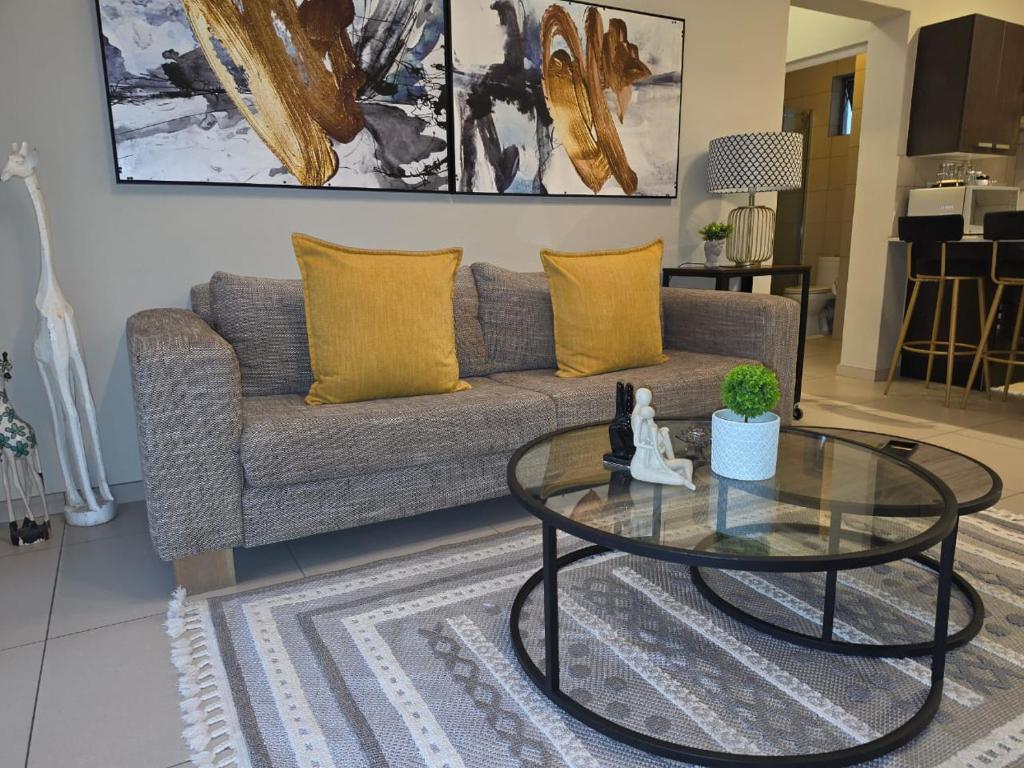 a living room with a couch and a glass table at Classy and Cosy 5 in Fourways