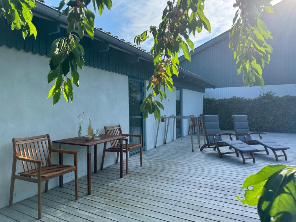 a wooden deck with chairs and a table and chairs at Tiny Guesthouse in Nakskov