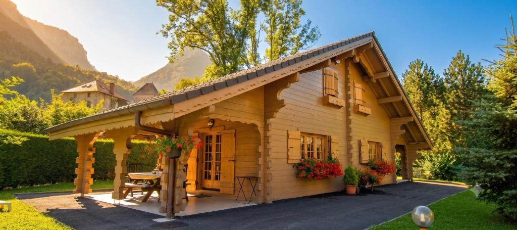 a small wooden cabin with a table in front of it at Chalet mitoyen 4 personnes in Alex