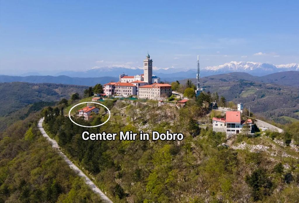 a house on top of a hill in the mountains at Center Mir in Dobro, Pax et Bonum Guesthouse in Solkan