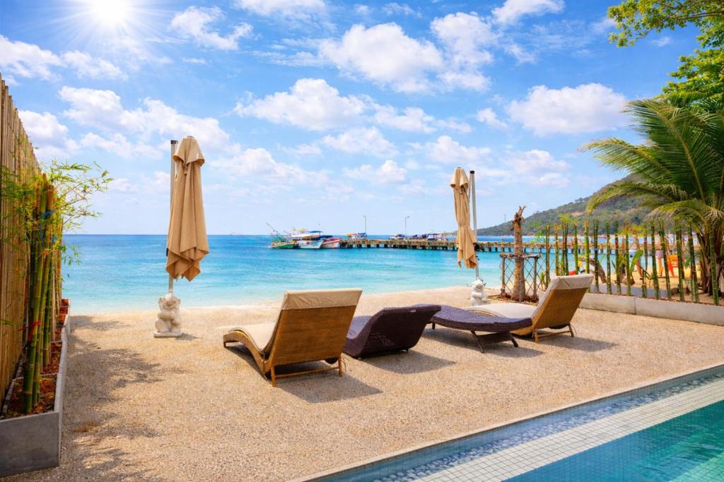 a view of the beach with chairs and umbrellas at Beachfront 4BR Villa with Private Pool - Ocean Access in Chaloklum