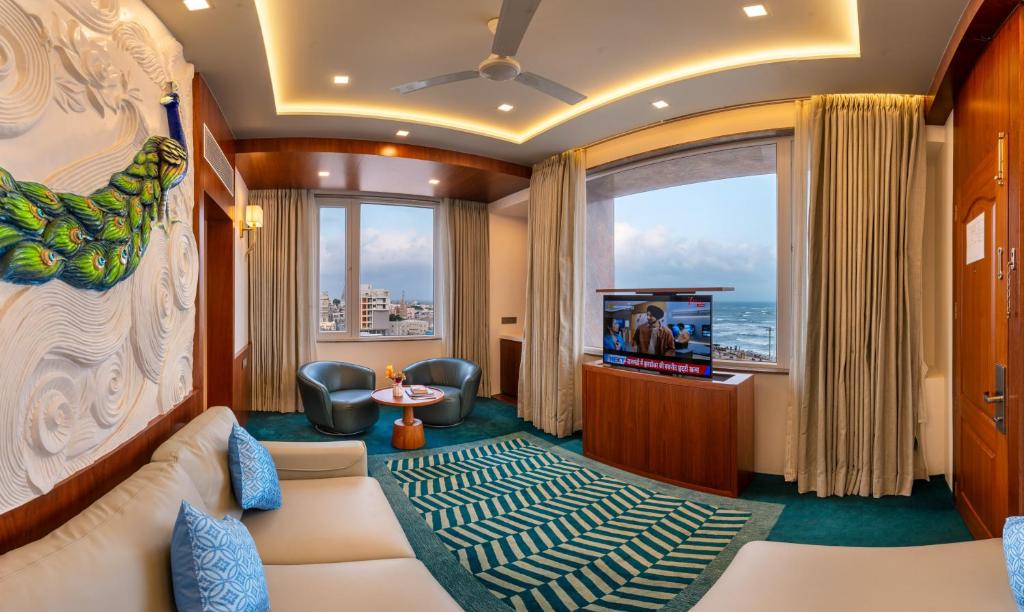 a living room with a couch and a tv at Dwarkadhish Lords Eco Inn Dwarka - Pure Veg in Dwarka