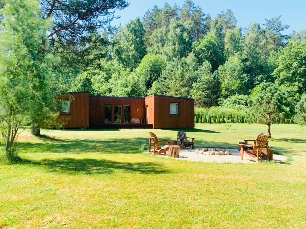 a small cabin in the middle of a grass field at Kabakėlio slėnis in Kabakelis
