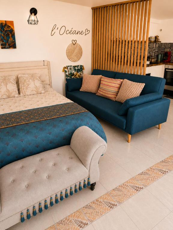 a bedroom with a blue bed and a couch at L'océane in Saint-Maurice-de-Beynost