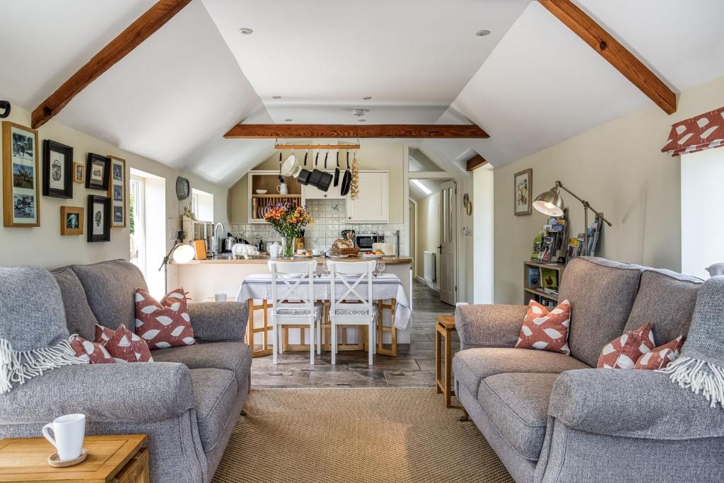 a living room with two couches and a table at Downclose Piggeries in North Perrott