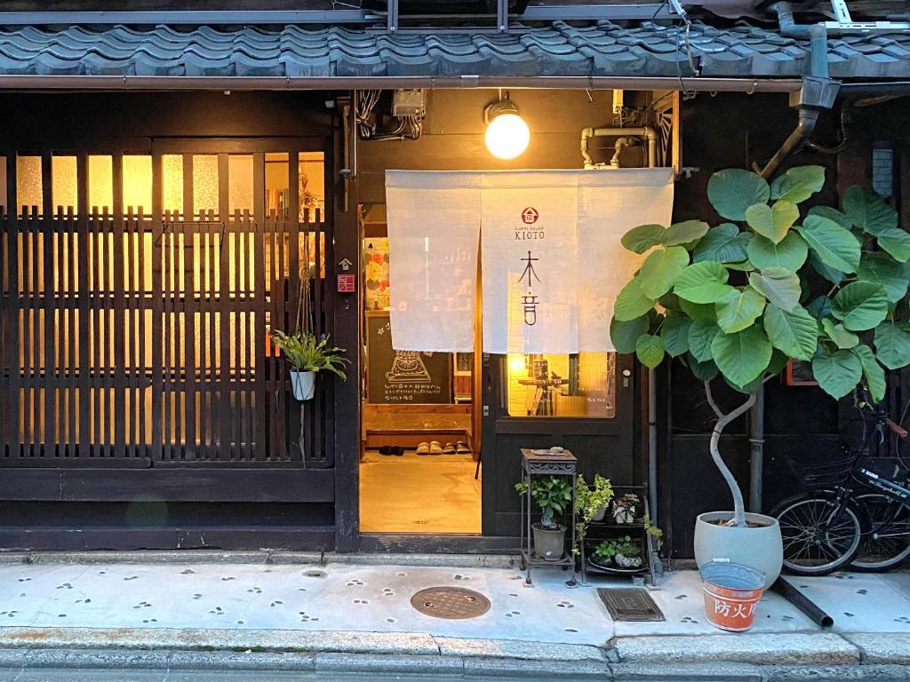 a building with a door with a plant in front of it at Guesthouse Kioto in Kyoto