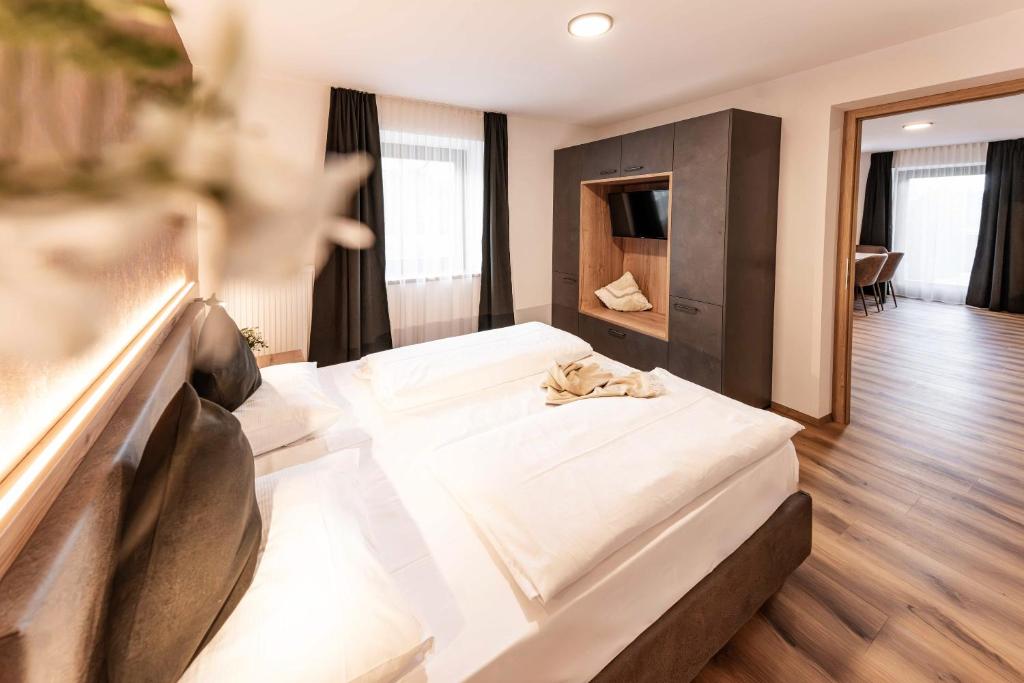 ein Schlafzimmer mit einem großen weißen Bett in einem Zimmer in der Unterkunft Wonga Apartments in Gais