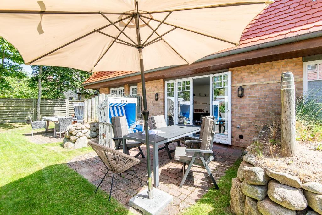 a patio with a table and an umbrella at Haus Maybachstraße in Westerland