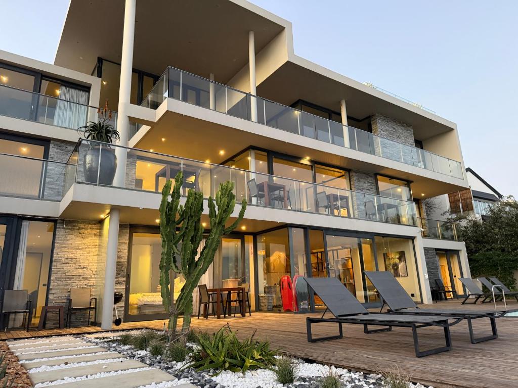 an apartment building with two chairs and a patio at The Ocean View Guest House in Wilderness