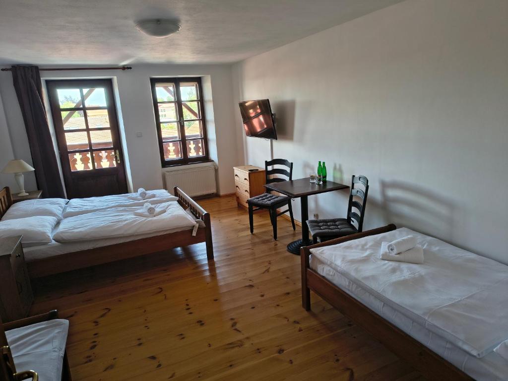 a room with two beds and a table and chairs at MiMo penzion in Telč