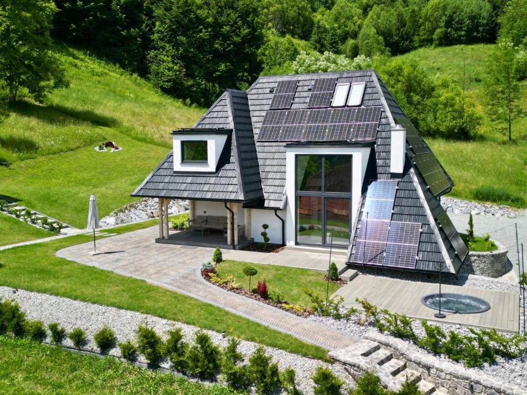 a small house with solar panels on the roof at Sol Chalet Maramures in Borşa