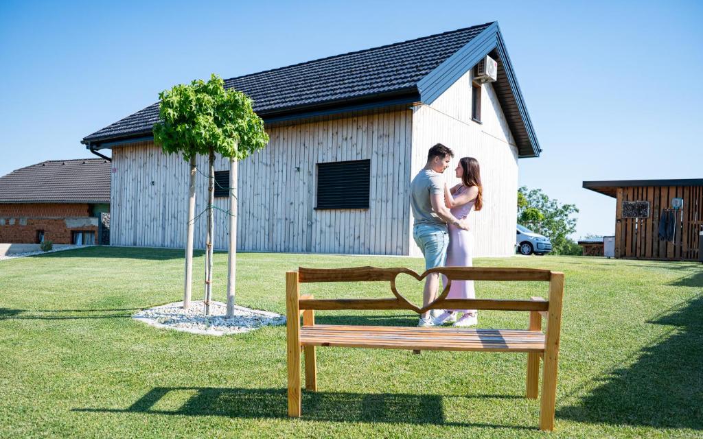 a man and a woman standing next to a bench at RANČ Dida in Ženavlje