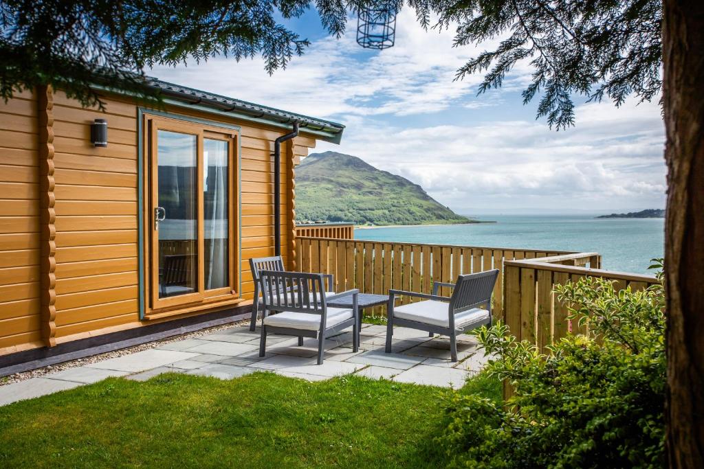a house with two chairs and a table on a patio at Oakbank Farm in Lamlash