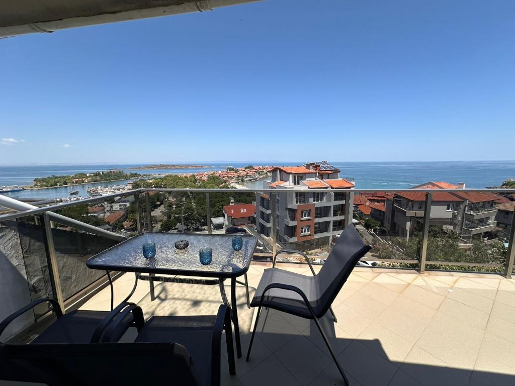 a balcony with a table and chairs and the ocean at Hotel Filland in Sozopol