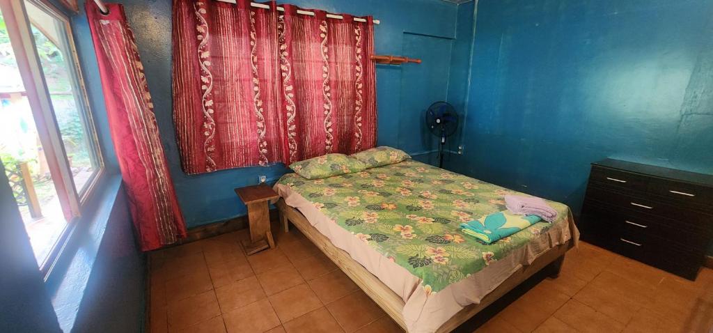 a small bed in a room with blue walls at Haekua Chez Mel in Nuku Hiva