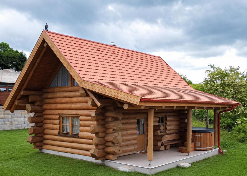 a log cabin with a red roof at Bándi Kuckó in Bánd