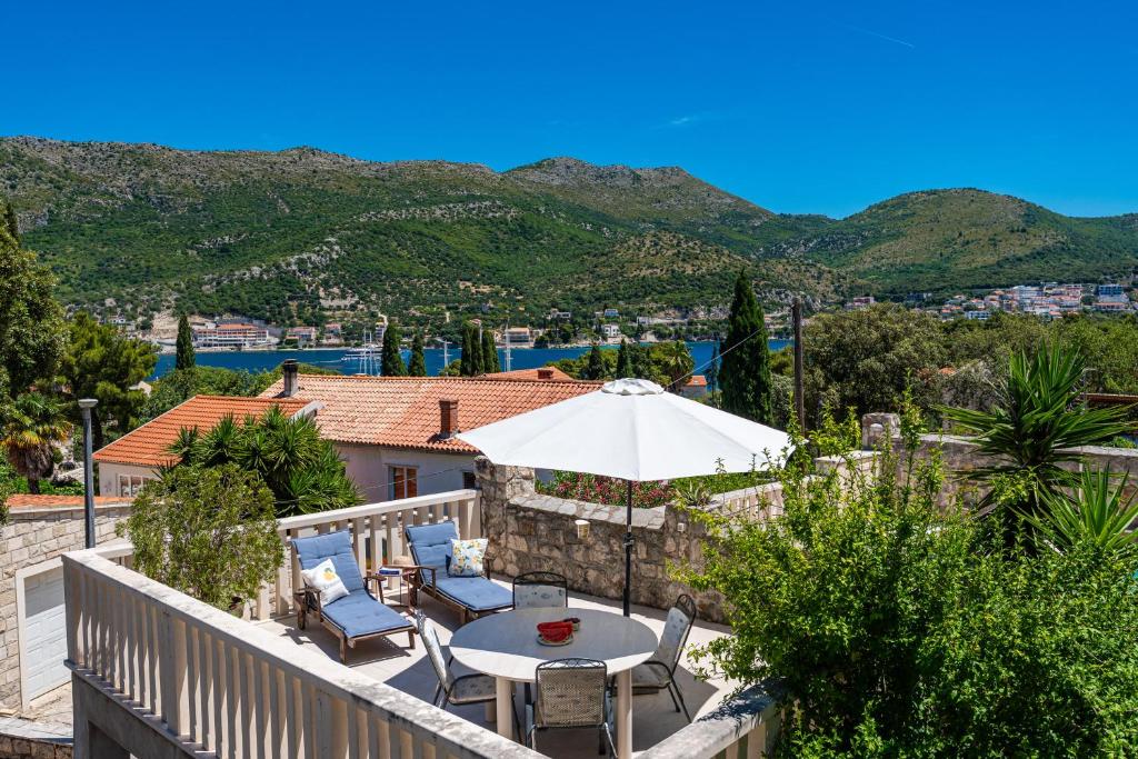 a balcony with a table and chairs and an umbrella at Hanas Dream Places in Zaton