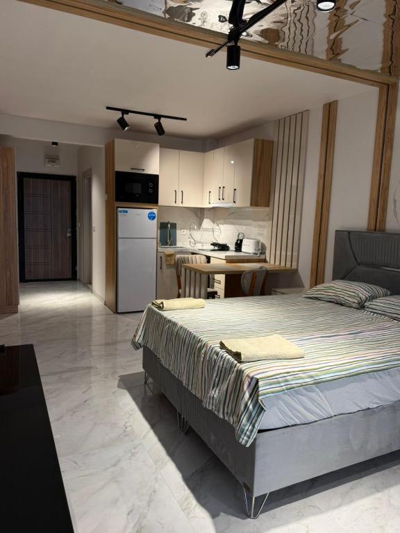 a bedroom with a large bed and a kitchen at Azur Properties 74 in Shkorpilovtsi