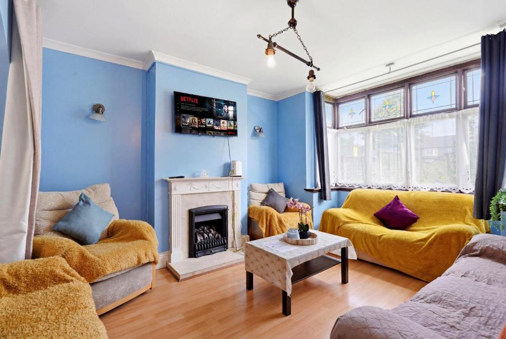 a living room with blue walls and yellow furniture at 4 Bedroom Central Birmingham in Birmingham