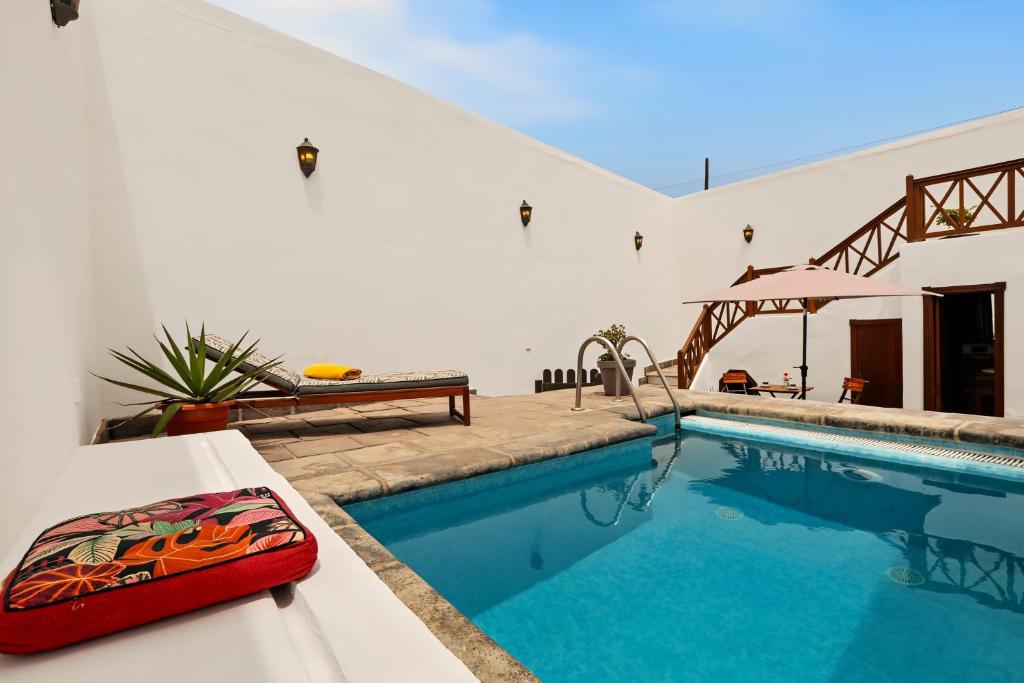 a pool in a house with a red pillow on a table at Rincón de Daute in Los Silos