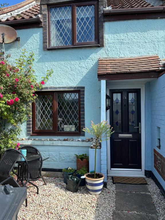 a blue house with a black door and windows at Turning Tides Holiday Cottage in Great Yarmouth