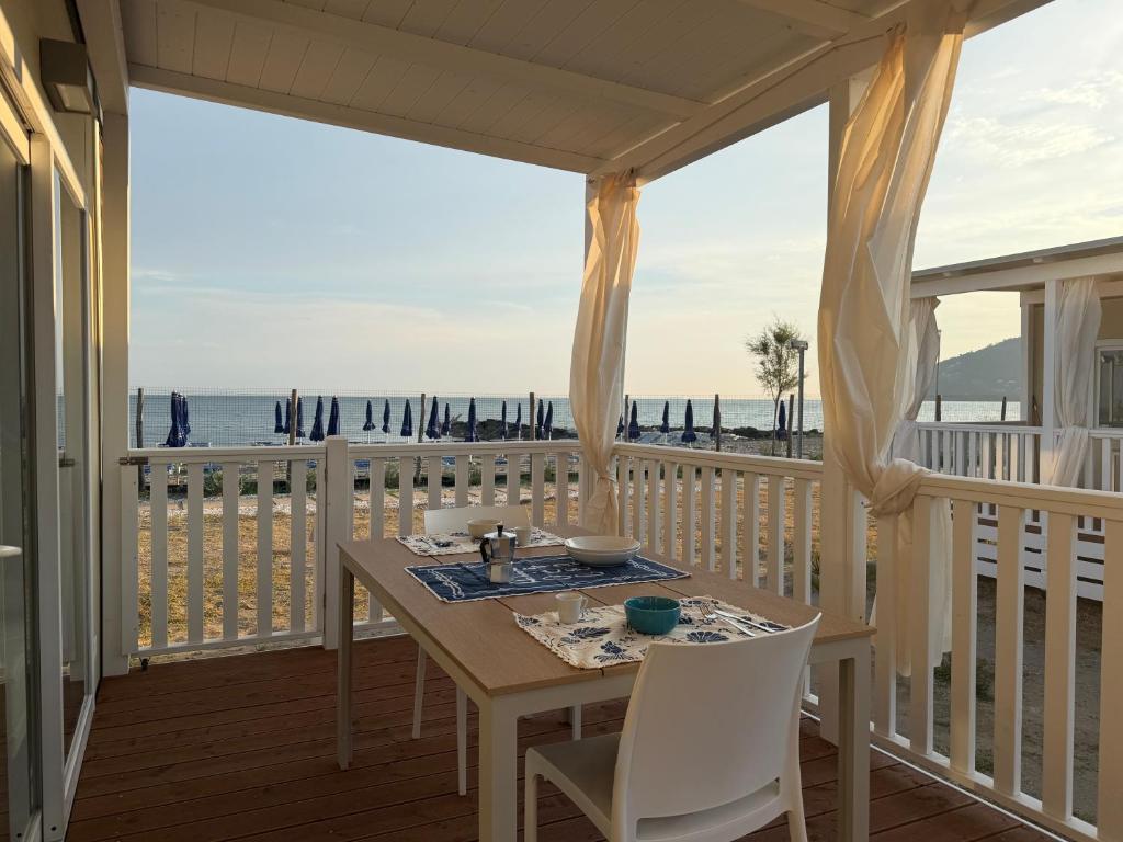 a dining room with a table and a view of the beach at The Beach Camping Village in Marina di Carrara