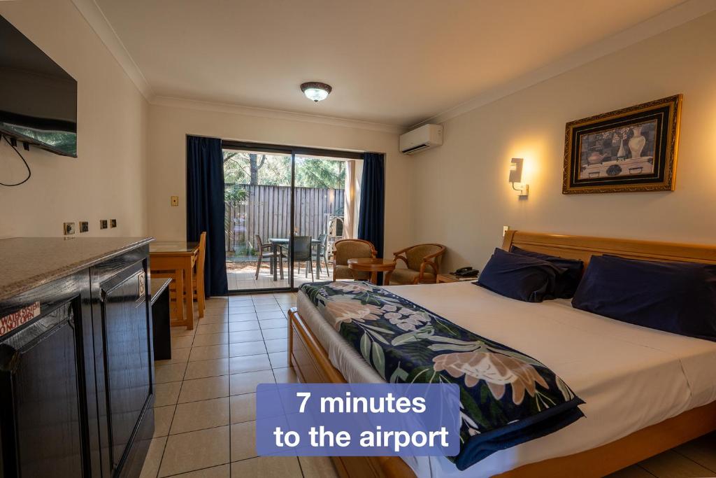 a hotel room with a bed with minutes to the airport at Novena Palms Motel in Brisbane