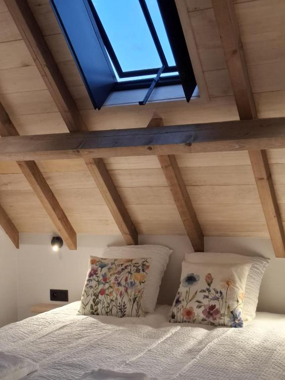a bedroom with a bed and a skylight at De Flamberthoeve in Ieper