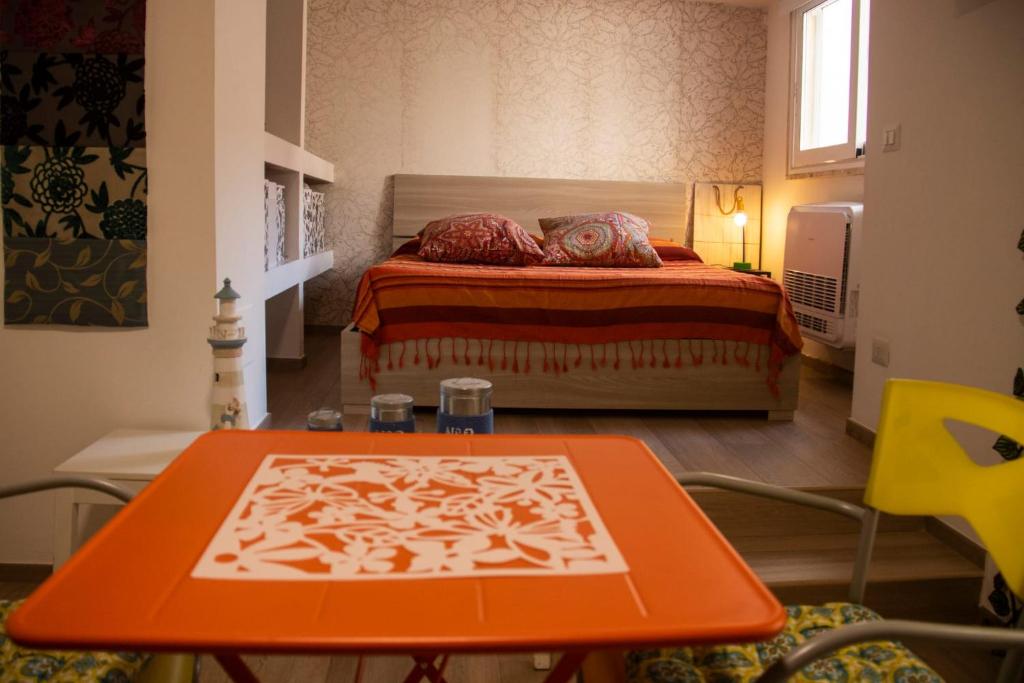 a bedroom with a bed and a table in front of it at Rosu in Triggiano