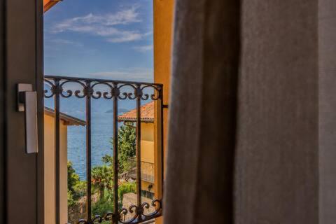 a room with a balcony with a view of the ocean at La Corte del Lario - Contrada dei Sarti in Varenna
