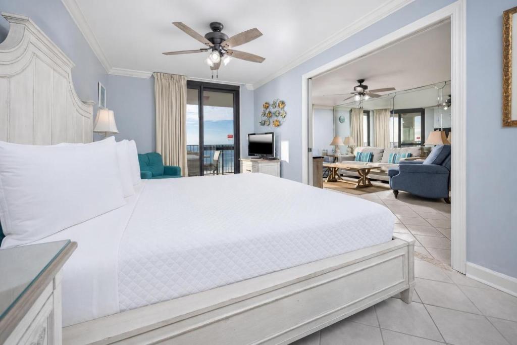 a bedroom with a large white bed and a living room at Phoenix VI 61004 in Orange Beach