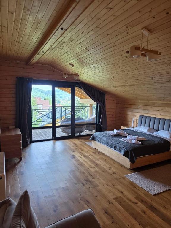 a bedroom with a large bed in a wooden room at Гірська Лаванда in Skhidnitsa