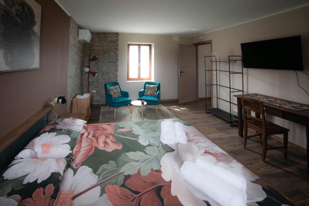a bedroom with a bed and a desk and a television at Casale Rûsignul in Cassegliano
