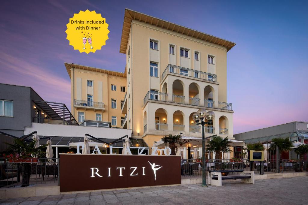 a hotel with a sign in front of a building at BO Hotel Palazzo in Poreč