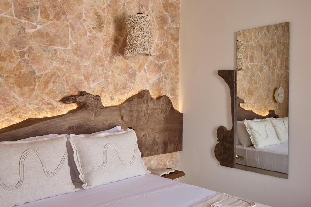 a bedroom with a bed and a mirror at Oikia Pouloudi in Kimolos