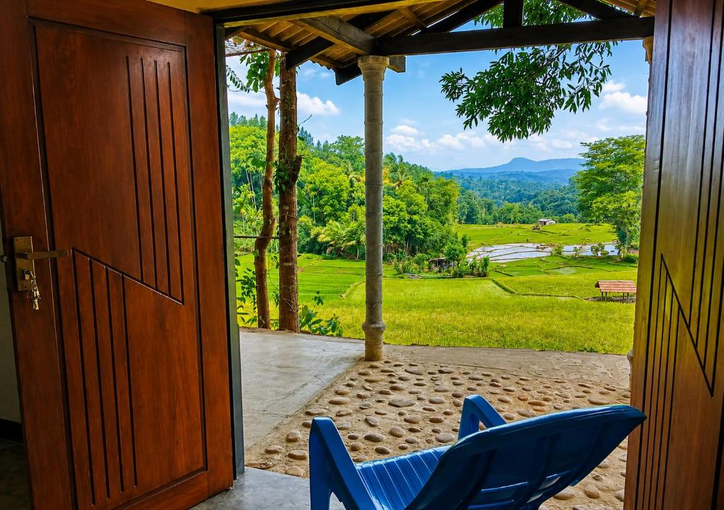 a pair of blue chairs on a porch with a view at Belihuloya Escape and Cafe in Belihuloya