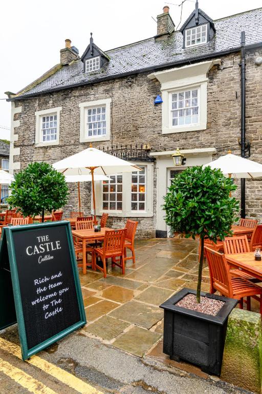 a restaurant with tables and chairs and a sign at The Castle by Innkeeper's Collection in Castleton