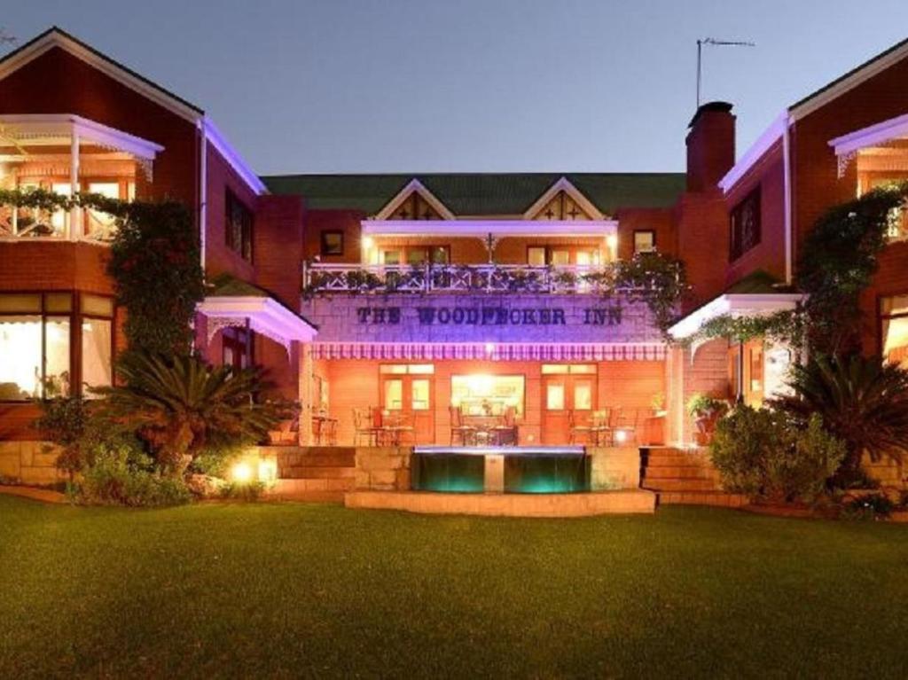 a building with a purple sign on the front of it at The Woodpecker Inn in Pretoria