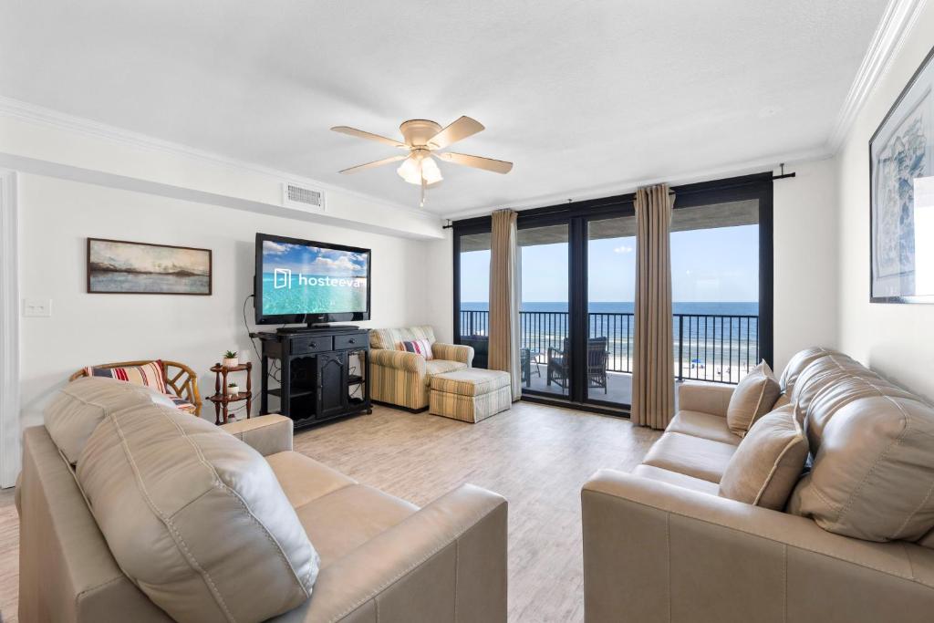 a living room with a couch and a flat screen tv at Wind Drift South East 404 in Orange Beach