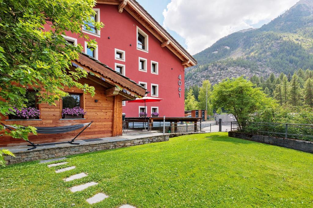 a red building with a hammock outside of it at Punta Ceresole 4061 Maison Gerard in Cogne