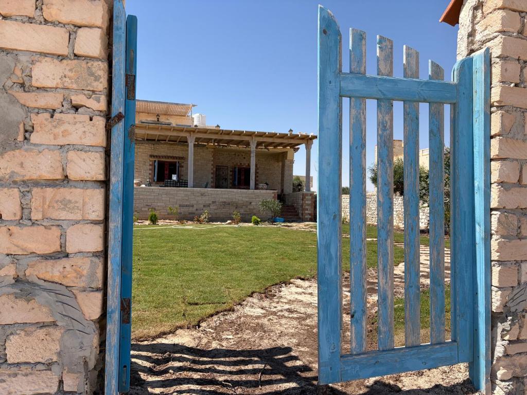 an open blue gate in front of a house at Al Obayed Garden Villa in Marsa Matruh